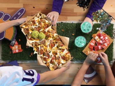 Taco Bell's nacho party pack ad showing three people around a table reaching for a bowl of nacho's